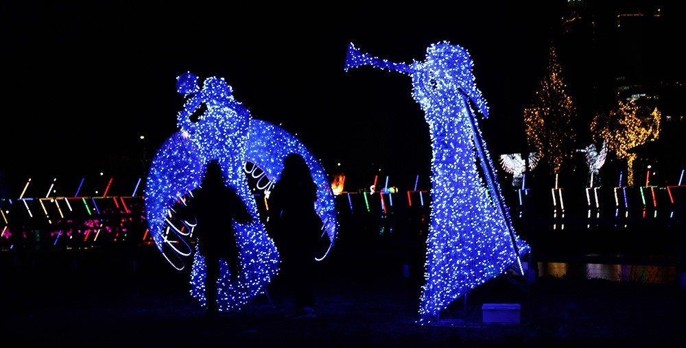 가족 존에 설치된 나팔 부는 천사 조형물 앞에서 사진 찍는 방문객들