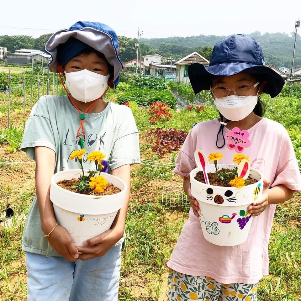 고사리 손으로 심은 화분을 소중하게 들고 있는 아이들