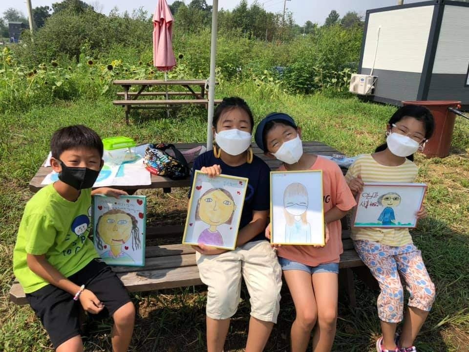 직접 그린 그림을 들고 환하게 웃는 어린이들