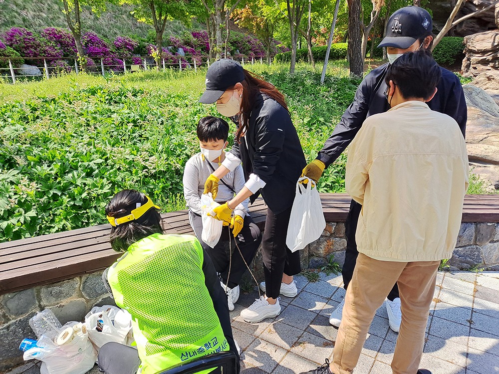 쓰레기 봉투에 모으기 위해 쓰레기를 가져온 가족들